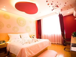 Une chambre d’hôtel avec un lit, une table de chevet et une grande fenêtre avec des rideaux.