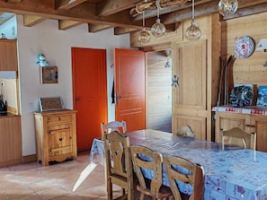 A rustic interior with wooden furniture, a dining table, and a kitchen area.