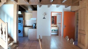 A compact kitchen with a washing machine, a sink, and a small dining area with a table and chairs. - Chalet in Pra Loup 1500 with 4 bedrooms for 12 people (Pra-Loup)