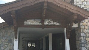 Une entrée d’immeuble avec une façade en pierre et un auvent en bois.