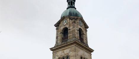 En historisk bygning med et markant tårn med ur, buede vinduer og en kuppel.