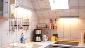 A kitchen with a sink, stove, and various appliances. - Vacation apartment 1 - Apartments Riedel (Pegnitz)