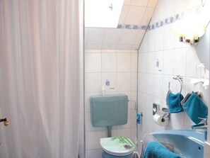 A bathroom with a toilet, sink, and bathtub. - Vacation apartment 1 - Apartments Riedel (Pegnitz)