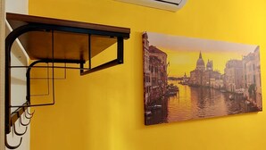 A yellow wall with a basketball hoop and a painting of a canal city. - Ca Barozzi (Venezia)