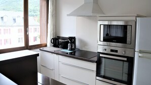 Ett modernt kök med inbyggd mikrovågsugn, ugn och kaffebryggare.