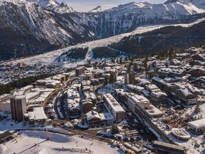 Uma cidade coberta de neve, com edifícios e uma pista de esqui.