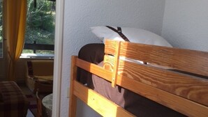 Une petite pièce agréable, dotée d’un lit superposé, d’une chaise et d’une table.