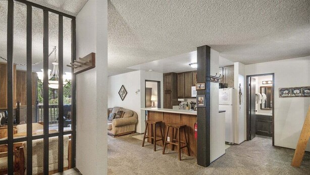 A spacious living area with a kitchen, a dining area, and a bar. - Crestview 29:  Walk to the Village, Near Blue Line (Mammoth Lakes)