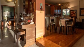 Een ruime woonkamer met een houten eettafel, stoelen en een keuken op de achtergrond.