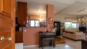 Een ruime woonkamer met een keuken, een eethoek en een zithoek met een bank en salontafel.