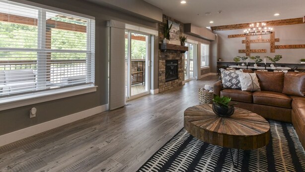 A spacious living room with a fireplace, a leather sofa, and a coffee table. - Lakeview, Indoor/Outdoor Pool, HotTub & Pet Frdnly (Branson)