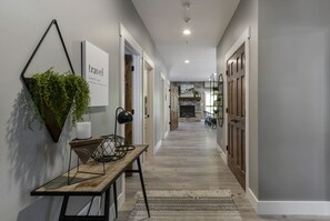 Stylish hallway with a bench, book nook, and fireplace leading to cozy rooms.