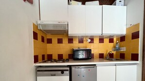 A compact kitchen with a microwave, stove, and dishwasher. - Cozy chalet-style apartment in Pra-Loup, 4 guests (Pra-Loup)