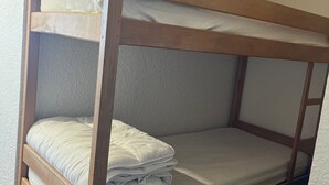 A bunk bed with two levels, each with a mattress and pillows. - Mountain Studio with Wifi 100m from Pra Loup 1600 Slopes (Pra-Loup)