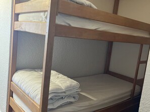 A bunk bed with two levels, each with a mattress and pillows. - Mountain Studio with Wifi 100m from Pra Loup 1600 Slopes (Pra-Loup)
