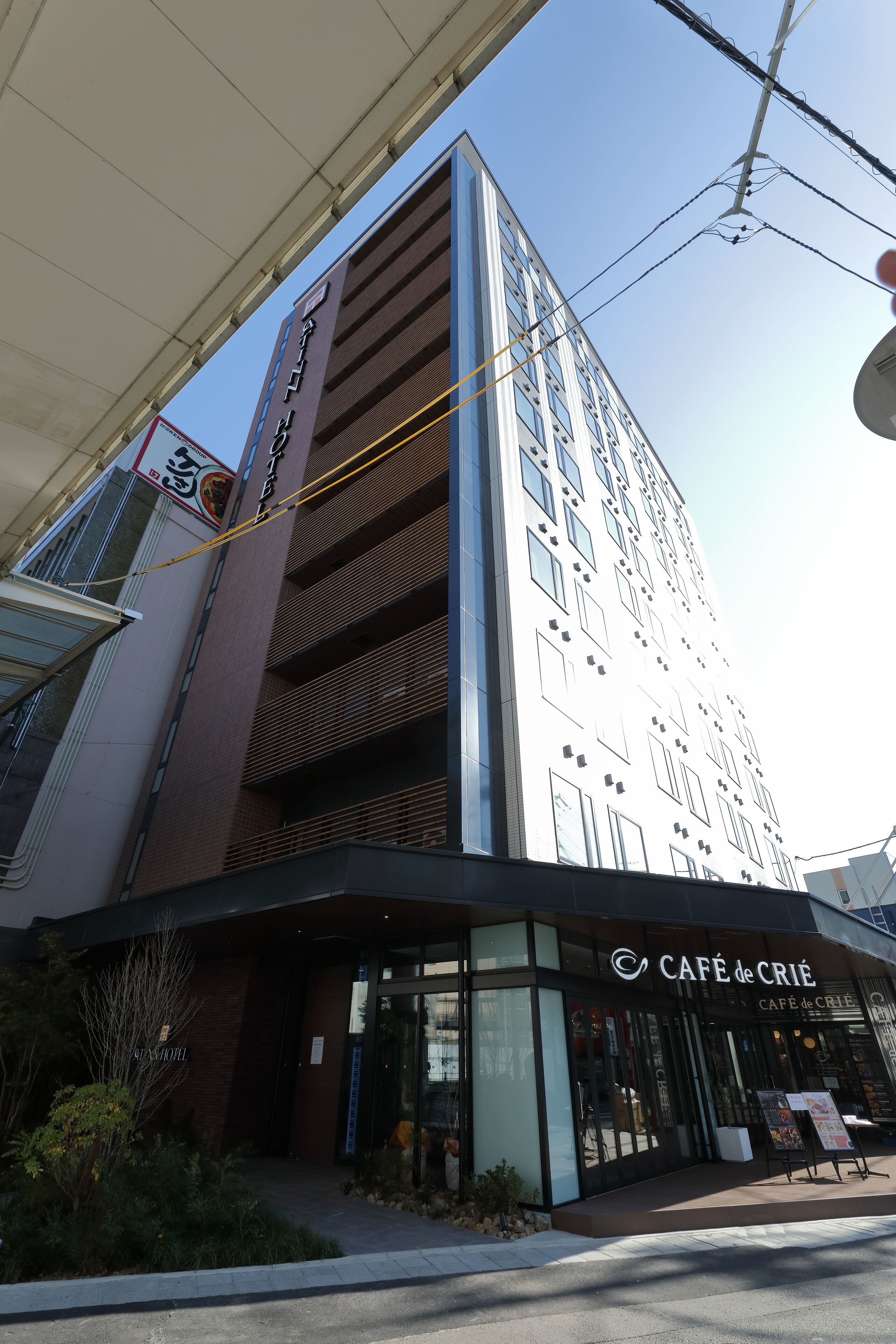 Un edificio de varios pisos con una cafetería llamada "Café de Crie" en la planta baja.