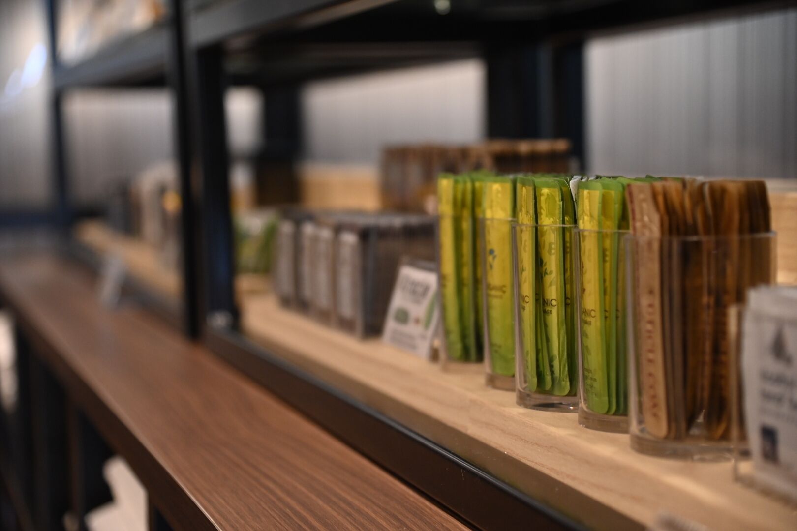 A display of green tea products on a wooden shelf in a store.