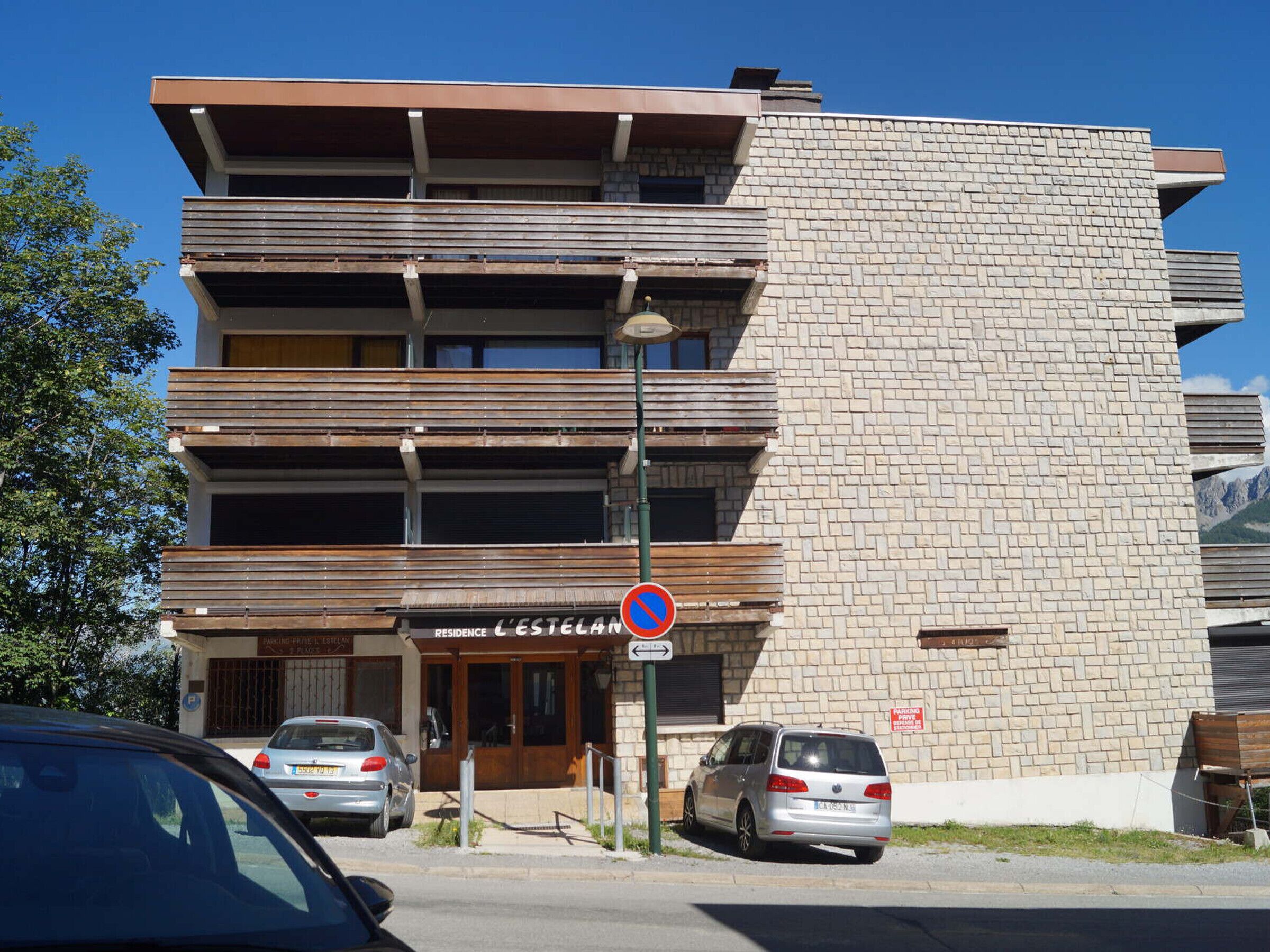 A multi-story building with a brick facade and a sign indicating a private parking area.