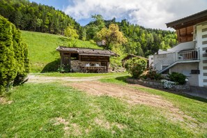 A rustic wooden cabin with a stone foundation, a dirt path leading to it, and a hillside backdrop. - Apartment “Familienwohnung” in “Schildhof Ebion” with Mountain View, Wi-Fi & Garden (St. Leonhard Passeier)