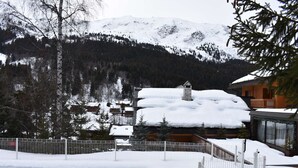 A snow-covered mountain village with traditional wooden houses, a stone chimney, and a white fence. - Ski-In/Ski-Out Studio for 4 in Méribel, Pool Access, Near Shops & Bus Stop (Méribel)