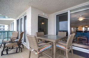 Enjoy meals on the balcony with a dining setup featuring four chairs and a table.
