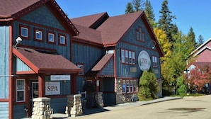 Ein zweistöckiges Gebäude mit einem Schild für das Wellnessangebot, Steinsäulen und einem Schild für das 'Lakeside Inn'.