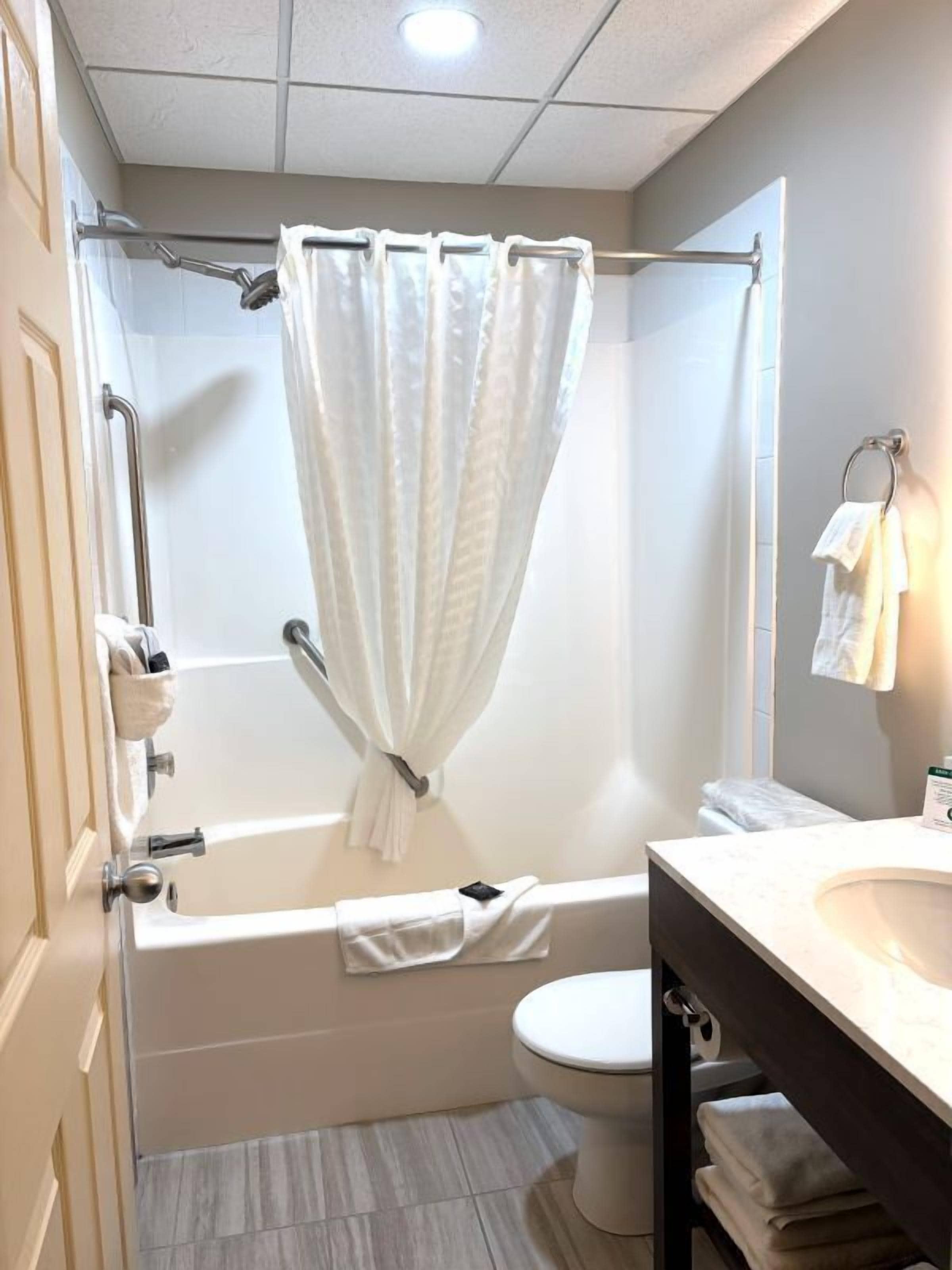 A bathroom with a bathtub, toilet, and sink.