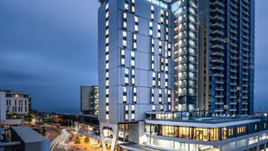 A modern Hilton Garden Inn hotel with multiple floors, a prominent entrance, and a view of the surrounding urban area. - Hilton Garden Inn Umhlanga Arch (Umhlanga)
