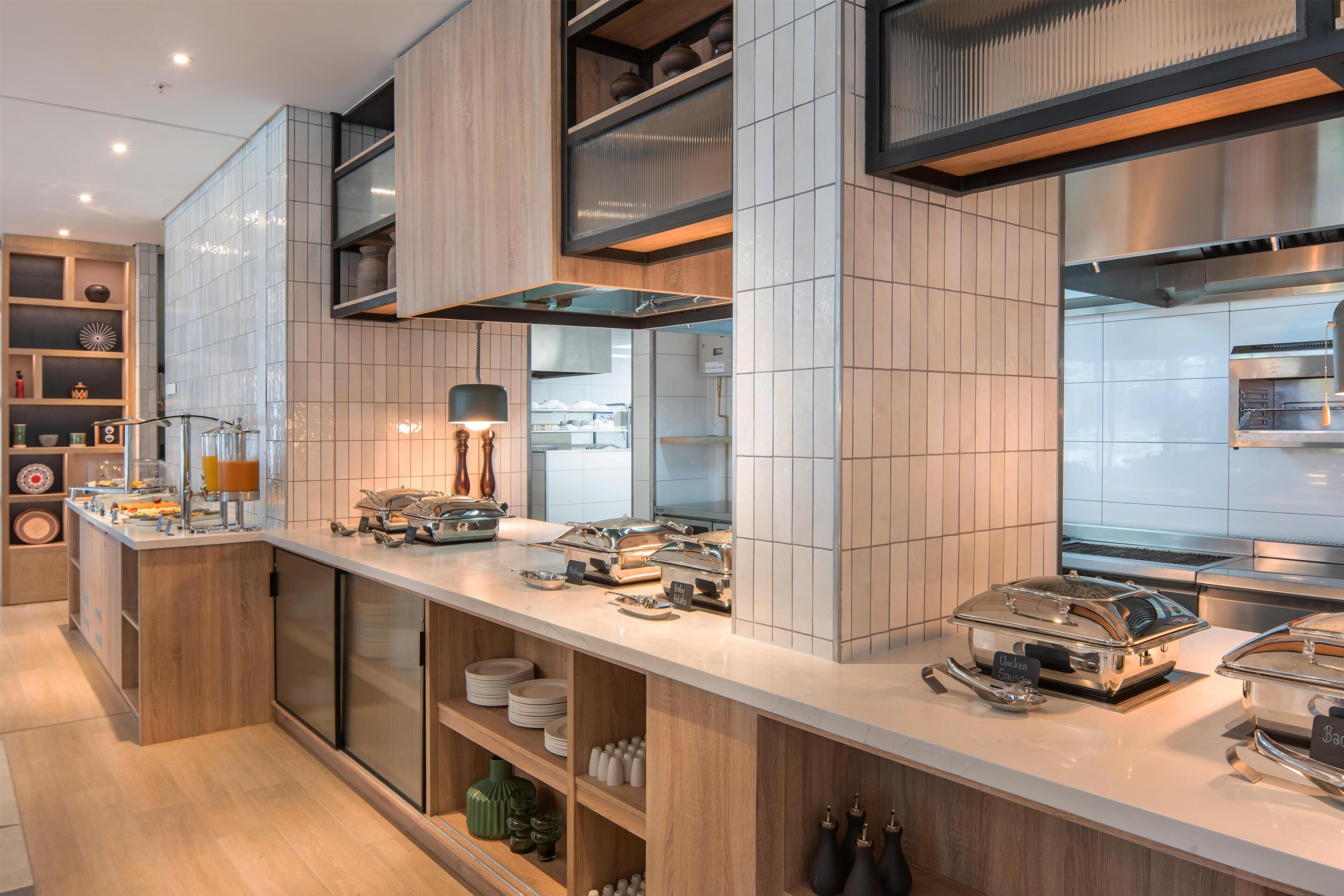 Una cocina moderna con una encimera amplia, estantes integrados y una variedad de electrodomésticos.