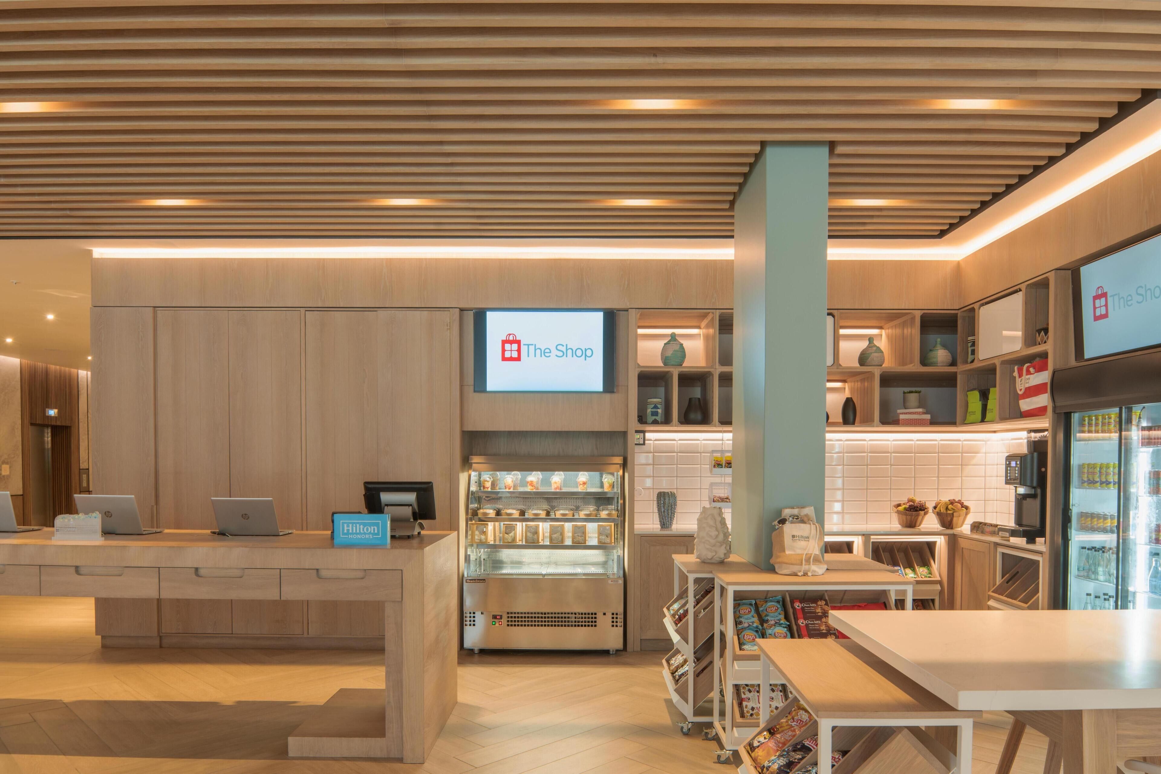 Egy hotel hall, amelyben található egy recepciós pult, egy digitális kijelző a „Bolt” számára, egy minibar és egy ülősarok.