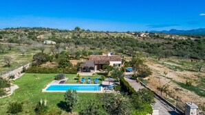Une villa avec piscine, entourée d’un jardin luxuriant et offrant une vue sur la mer.