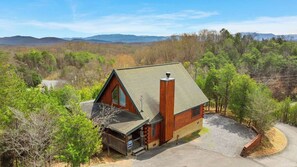 A cabin with a sloped roof, a chimney, and a porch. - Still Water Hideaway: Calm Waters, Quiet Escapes (Sevierville)