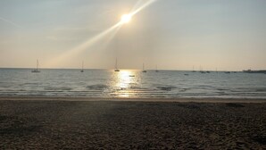 A beach with a calm sea, boats, and a clear sky. - Charming 3-bed Cottage in Swanage (Swanage)