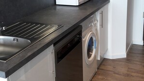 Cocina compacta con lavavajillas, microondas y lavadora.