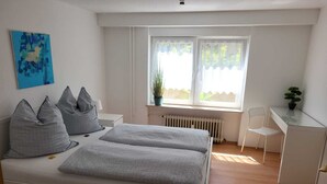 Un dormitorio con cama, escritorio y silla.