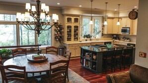 A spacious kitchen with a dining area, wooden furniture, and a chandelier. - Beautiful Charlotte Lake Wylie Waterfront Bungalow (Charlotte)