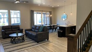 Un salon spacieux avec un canapé, une table basse et un coin repas.