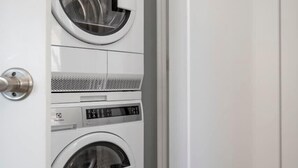 Une buanderie équipée de deux machines à laver à chargement frontal superposées.
