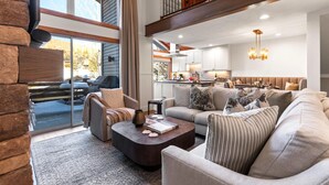 A spacious living area with a large sofa, a coffee table, and a fireplace.