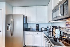 Enjoy cooking in this fully equipped kitchen with a refrigerator, coffee maker, and microwave.