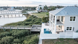 Uma propriedade à beira-mar com uma casa grande, um cais e uma piscina.