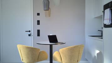 Una cocina moderna con una mesa redonda, dos sillas e iluminación colgante.