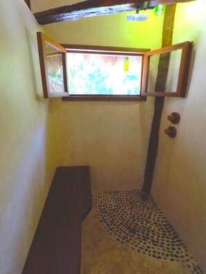 Cozy space with a sloped ceiling, featuring a window and a door with a round handle.