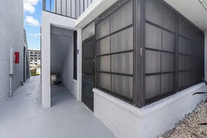 A building with a large glass door and a narrow entrance. - Pickleball, Pools & Docks - Yacht Club #165A (Madeira Beach)