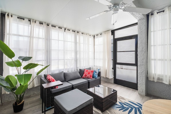 A modern living room with a sofa, coffee table, and potted plants. - Pickleball, Pools & Docks - Yacht Club #165A (Madeira Beach)