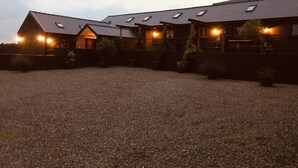 A large building with multiple windows and a gravel driveway. - Foxglove - Barn Conversion - Blossom  Farm (Haverfordwest)