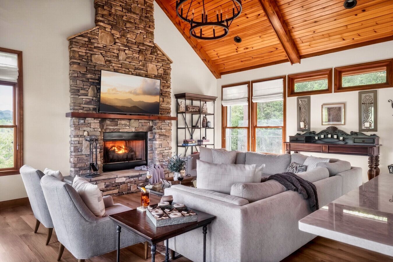 Una sala de estar con chimenea de piedra, un sofá grande y una mesa de comedor.