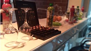 Un comptoir de cuisine avec une machine à café, une bouteille d’eau et un panier de fruits.