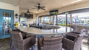 An outdoor bar area with a central island, wicker chairs, ceiling fans, and a view of the city. - 172 Balmoral (Haines City)