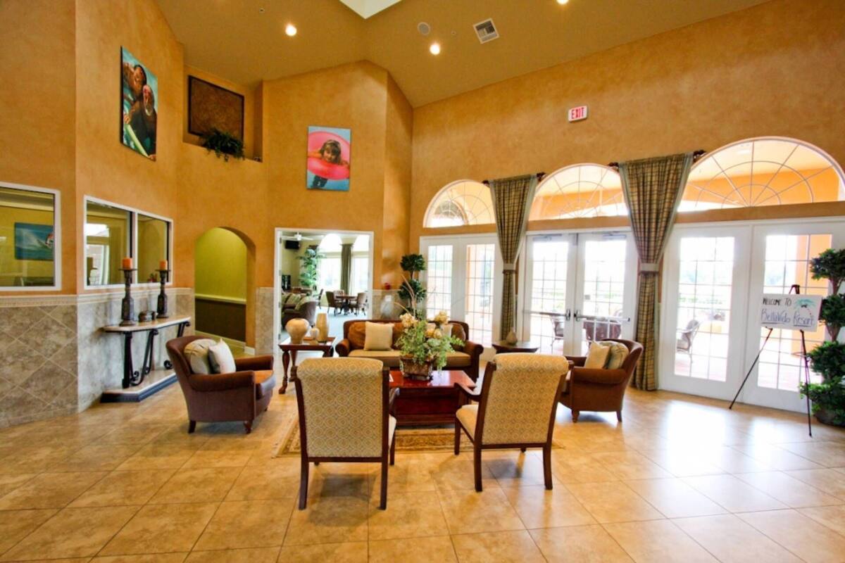 A spacious lobby with a high ceiling, comfortable seating, and large windows allowing natural light.